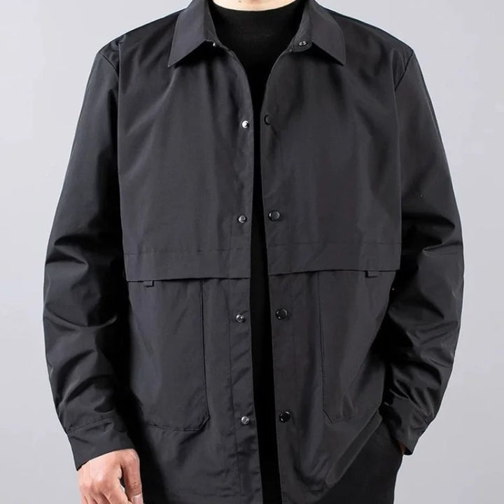 Man wearing black shirt jacket with snap buttons, front view