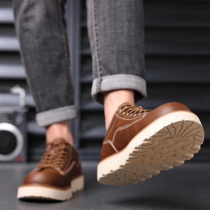 Brown leather oxford shoes worn with jeans showing sole tread