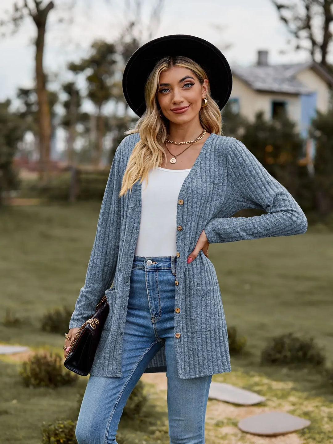 Woman in black hat wearing light blue ribbed knit cardigan