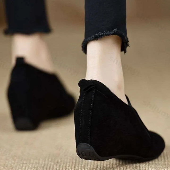 Black suede wedge booties rear heel view walking