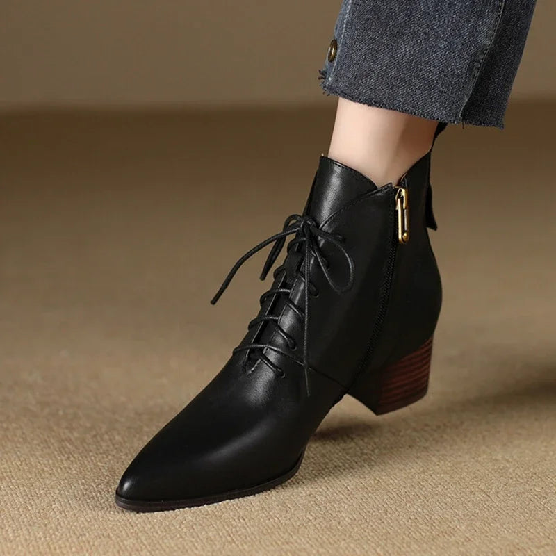 Black leather lace-up ankle boot worn on model, side view