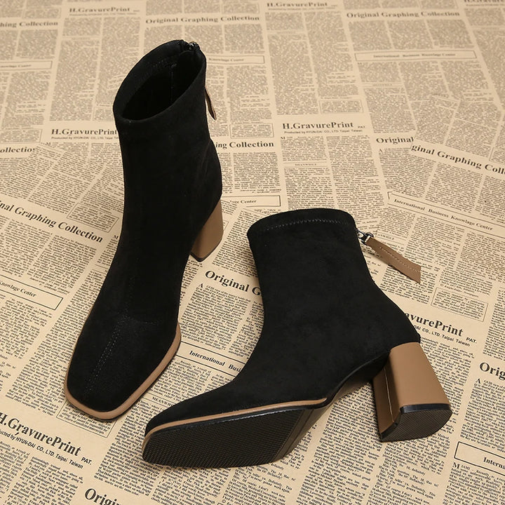 Black suede-look ankle boots shown from above with soles visible