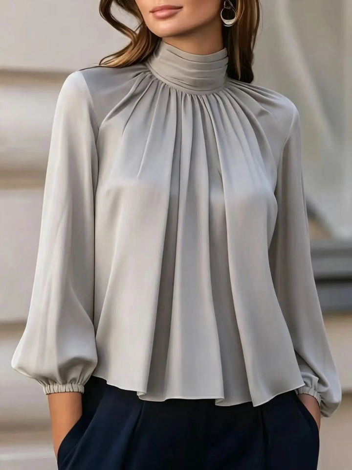 Close up of gray pleated mock neck blouse detail