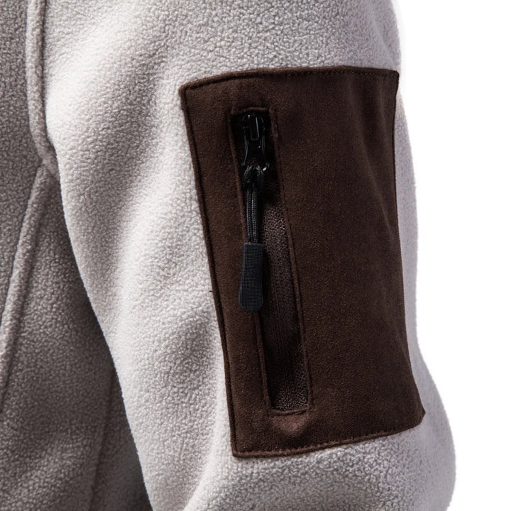 Close up of zippered sleeve pocket on apricot fleece jacket