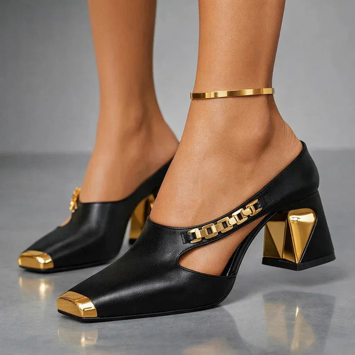 Close side profile of black mule pumps with gold sculpted heel and chain vamp trim