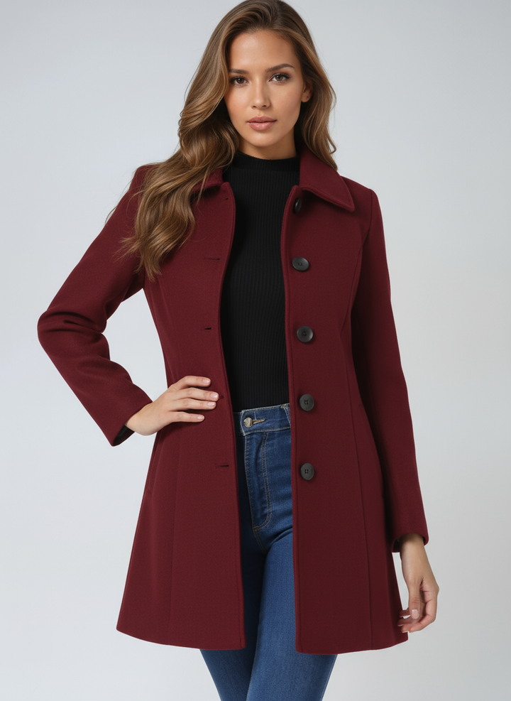 Woman wearing dark red fit and flare coat with hand on hip