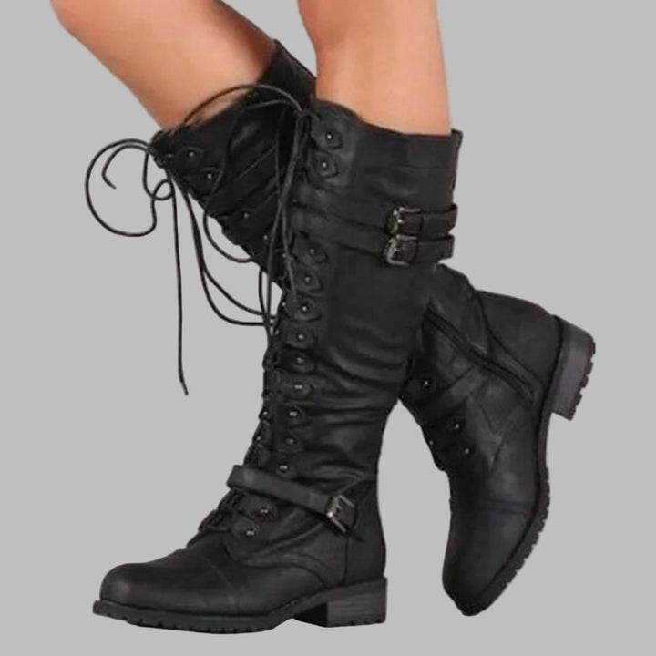 Black lace-up knee-high combat boots with buckle straps, side view