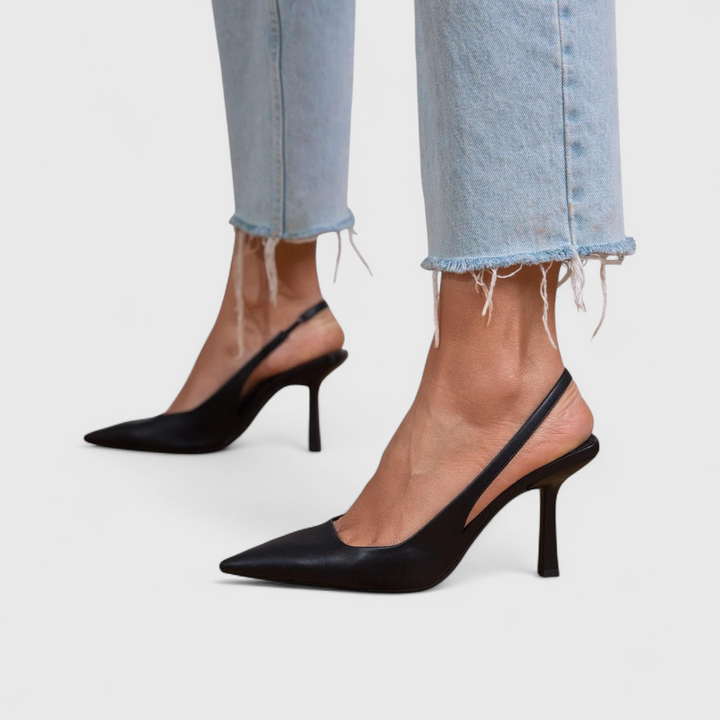 Black slingback pointed-toe pumps on model, both feet