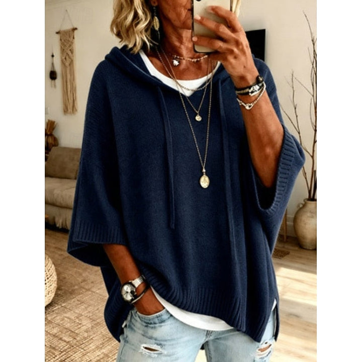 Navy blue hooded sweater worn with layered necklaces, front view