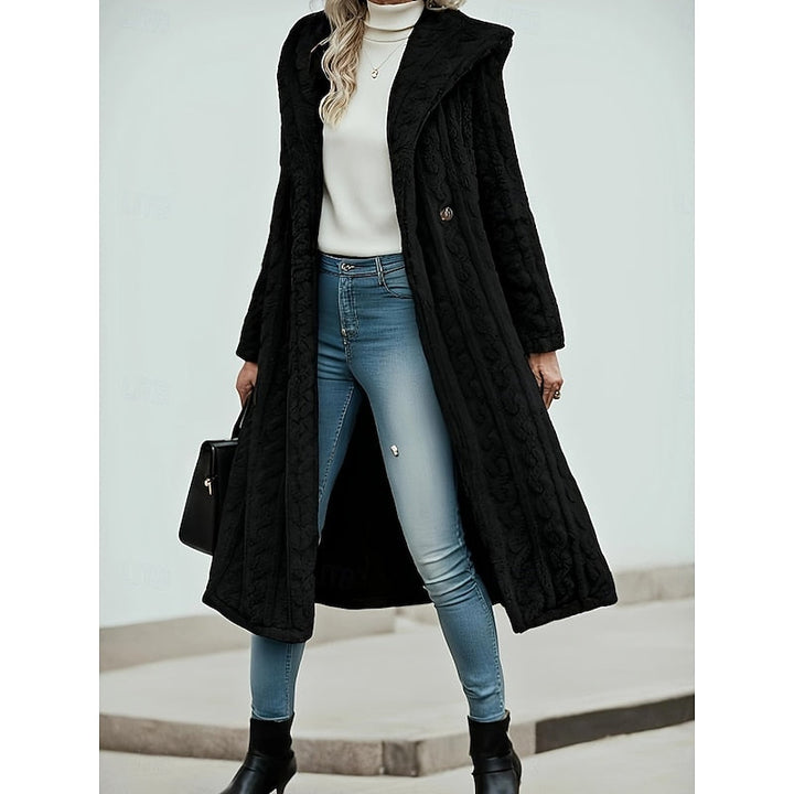 Woman wearing black textured hooded longline coat with front button closure