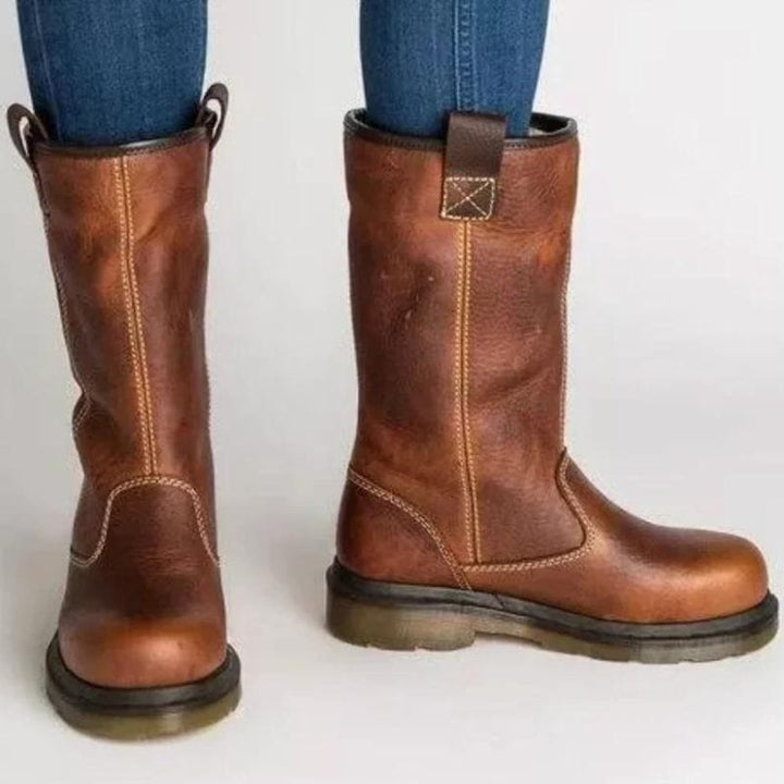 Back view of brown leather-look mid-calf boots showing contrast topstitching and grip-ready sole