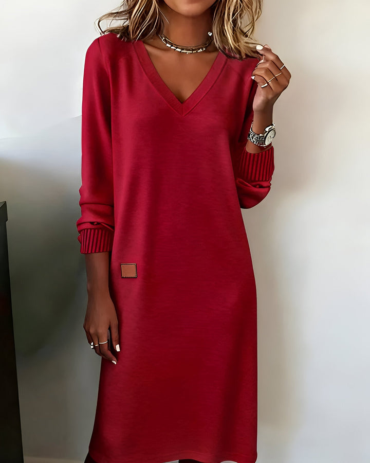 Woman wearing red V-neck midi dress with ribbed cuffs
