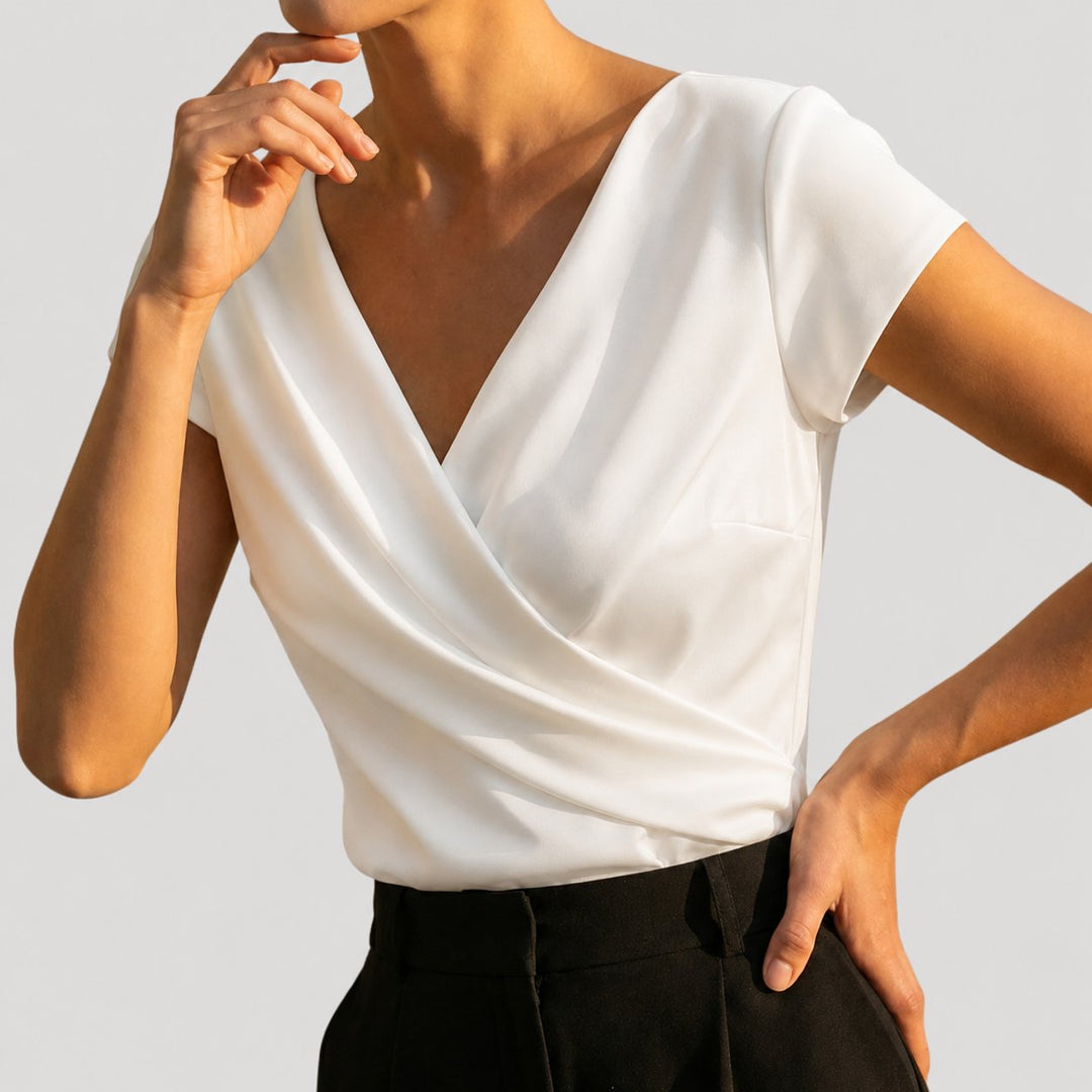 White wrap-front blouse styled with black trousers, side angle view