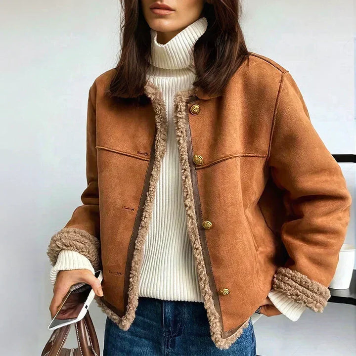 Woman wearing cropped brown shearling jacket with fleece collar and cuffs