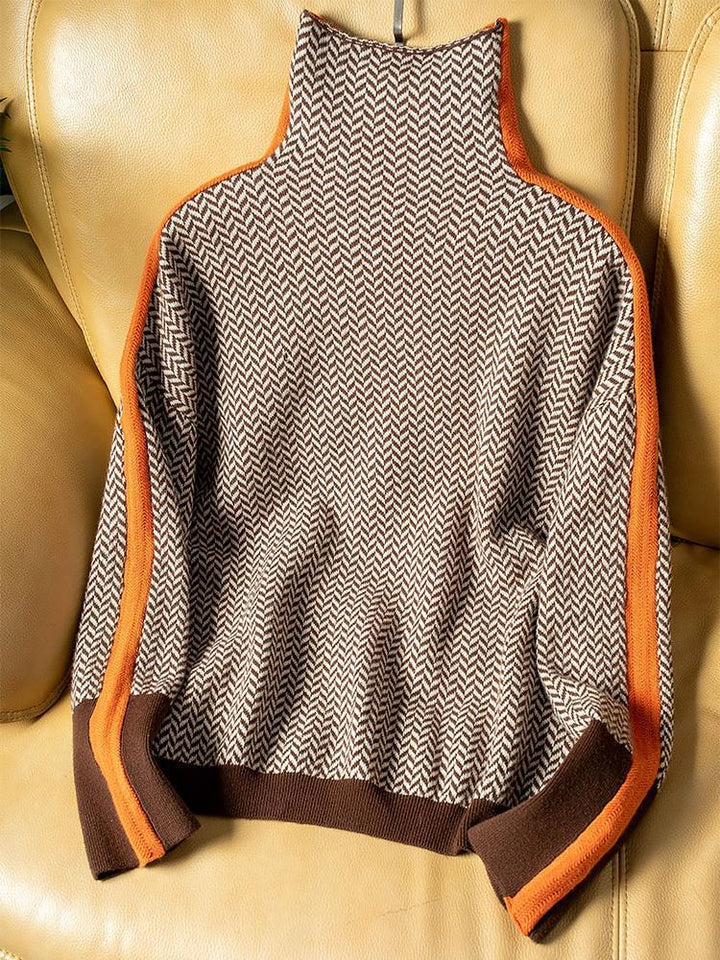 Back view of herringbone knit turtleneck sweater laid flat showing orange contrast stripes and ribbed cuffs