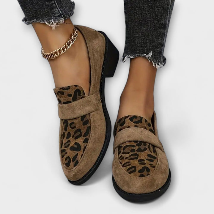 Leopard print loafers with gold ankle chain, angled view