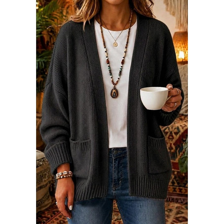 Woman wearing black open-front knit cardigan with patch pockets