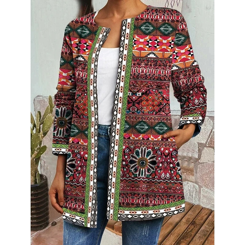 Woman wearing red patterned open-front jacket with contrast trim over white top and jeans