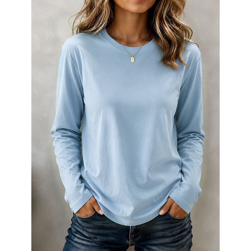 Woman wearing light blue long sleeve crew neck top with jeans, front view