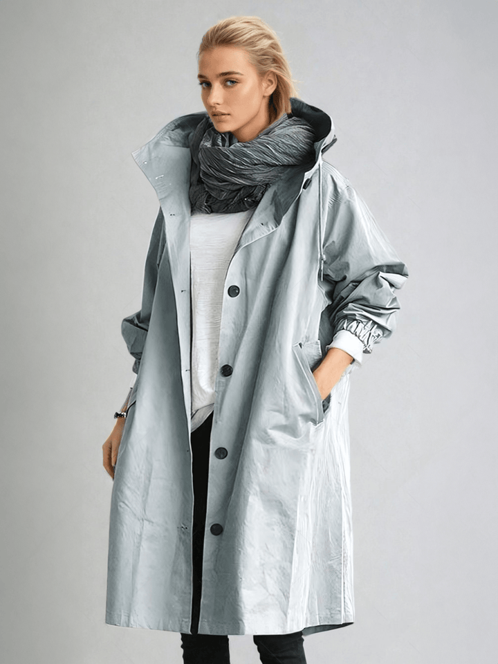 Woman wearing light gray oversized hooded trench coat with scarf, front view