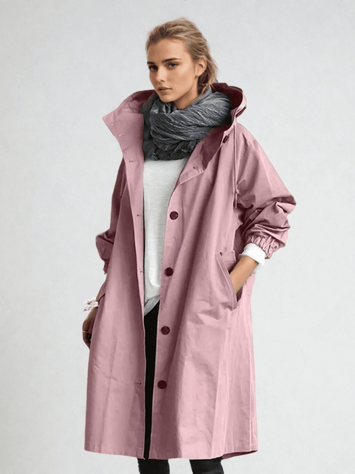 Woman wearing pink oversized hooded trench coat with scarf, front view