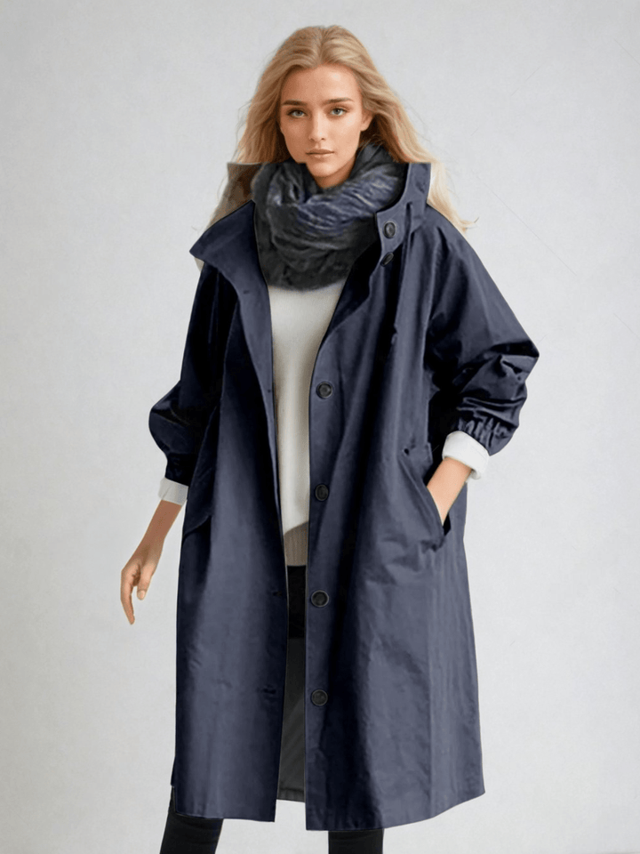 Woman wearing navy blue oversized hooded trench coat with scarf, front view