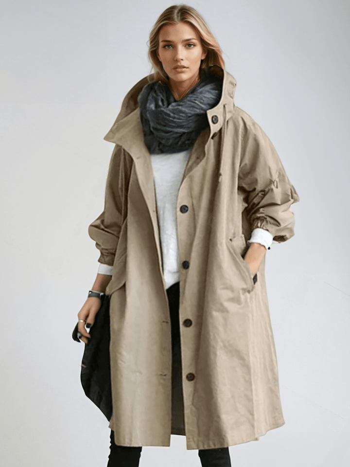 Woman wearing beige oversized hooded trench coat with scarf, front view