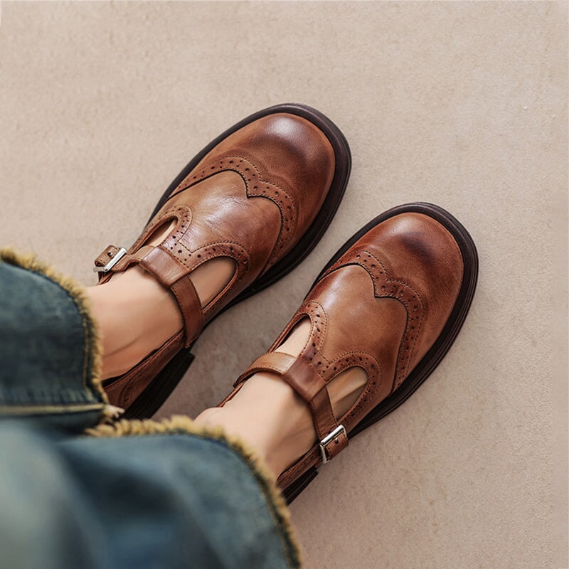 Close top view of brown wingtip Mary Jane flats worn on feet