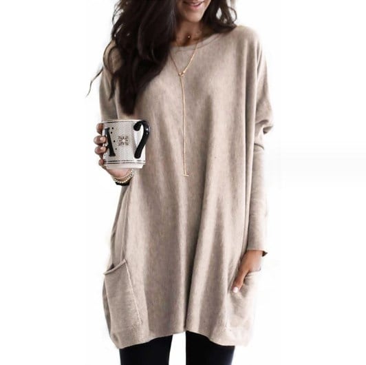 Woman wearing beige oversized tunic top with front pocket