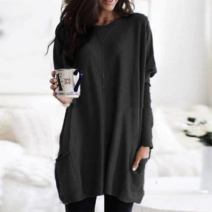 Woman wearing black oversized tunic top with front pocket