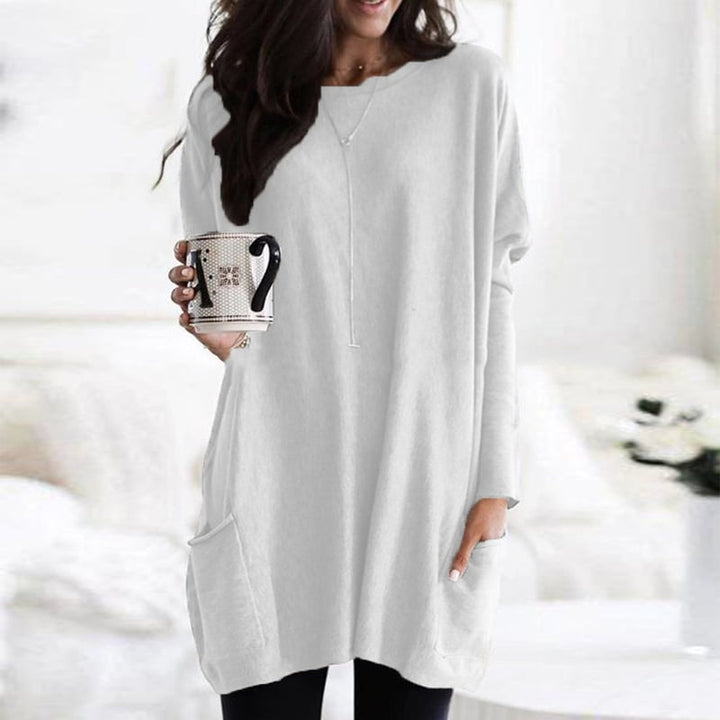 Woman wearing white oversized tunic top with front pocket