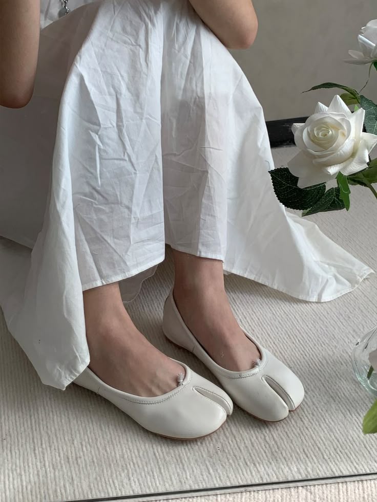 Beige split toe ballet flats paired with flowing white dress