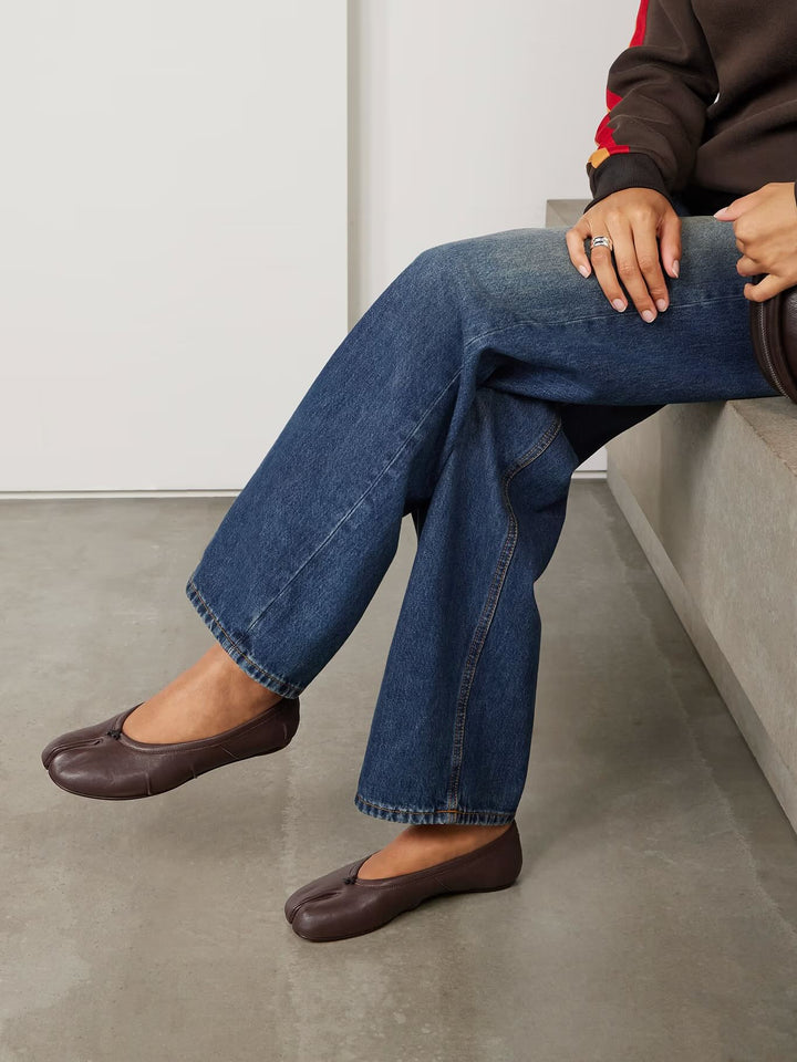 Model in jeans wearing burgundy split-toe flats