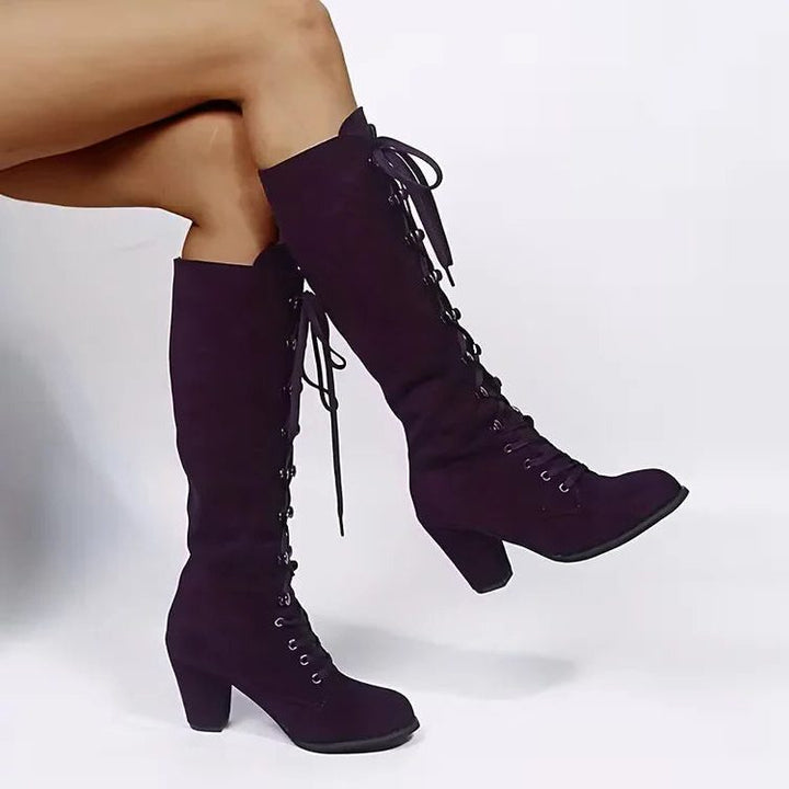 Purple lace-up knee high boots worn while seated