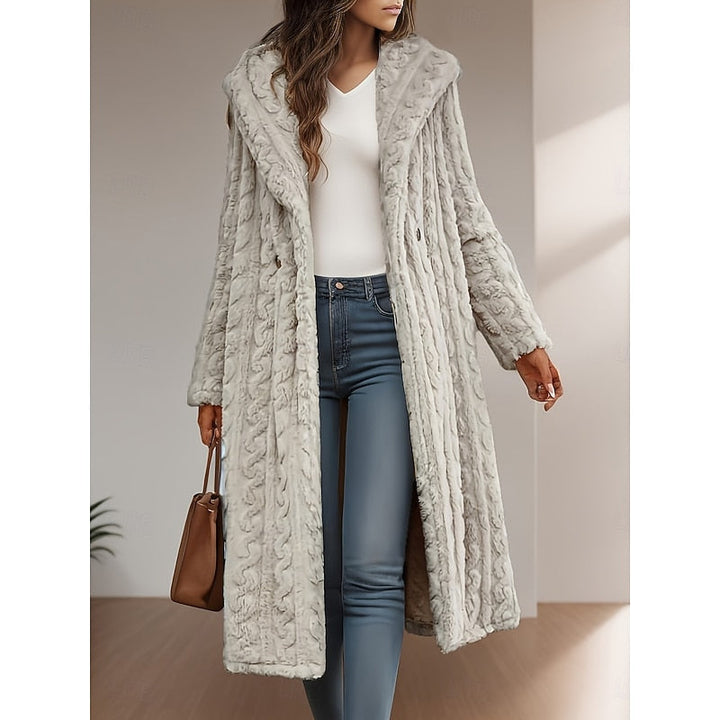 Woman wearing apricot textured hooded longline coat open over white top and jeans