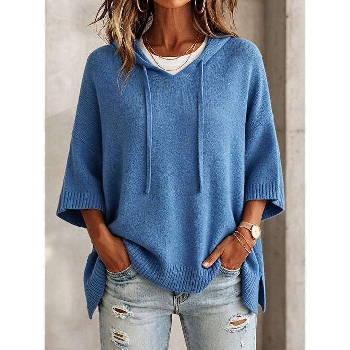 Woman wearing blue oversized hooded sweater with drawstring, front view